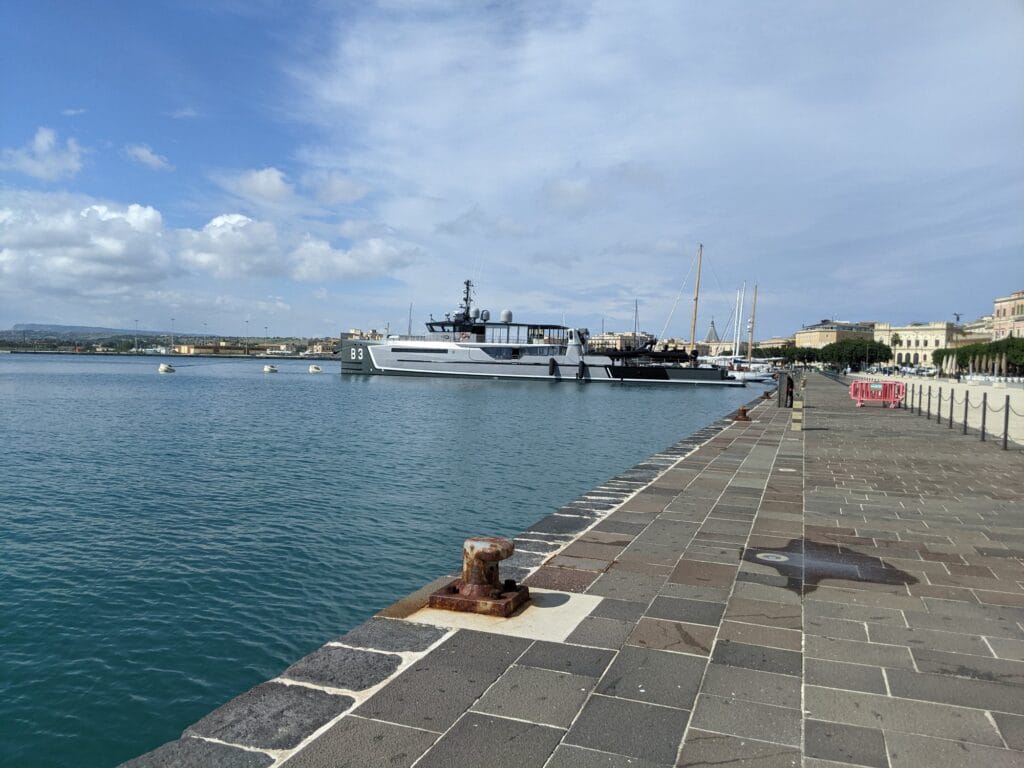 Kamienne nabrzeże Ortygii nad Porto Grande z zacumowanymi jachtami